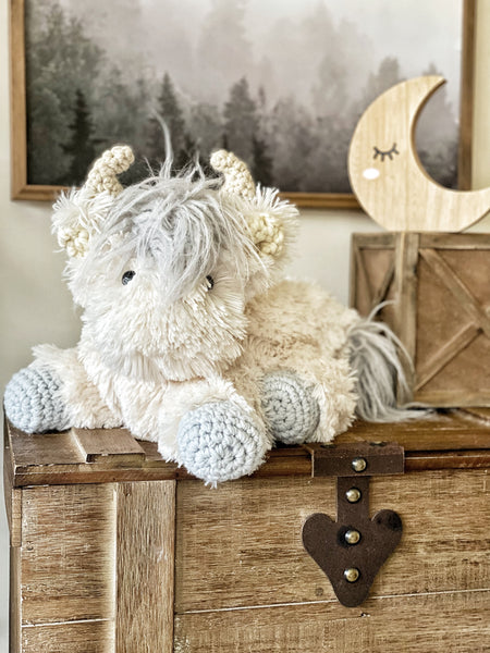 A highland cow stuffed animal with plush white and silver faux fur. 