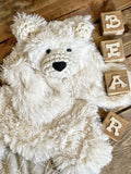 A plush white polar bear lovey made by ClaraLoo with soft faux fur and crocheted accents.